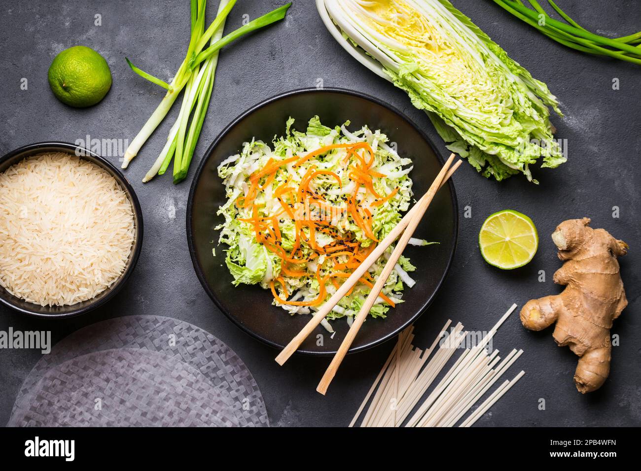 Vietnamesischer Salat. Frische Zutaten für die Zubereitung des vietnamesischen Abendessens: Reispapier, Reis, Nudeln, grüne Zwiebel, napakohl, Salat. Asiatische Kochzutat Stockfoto
