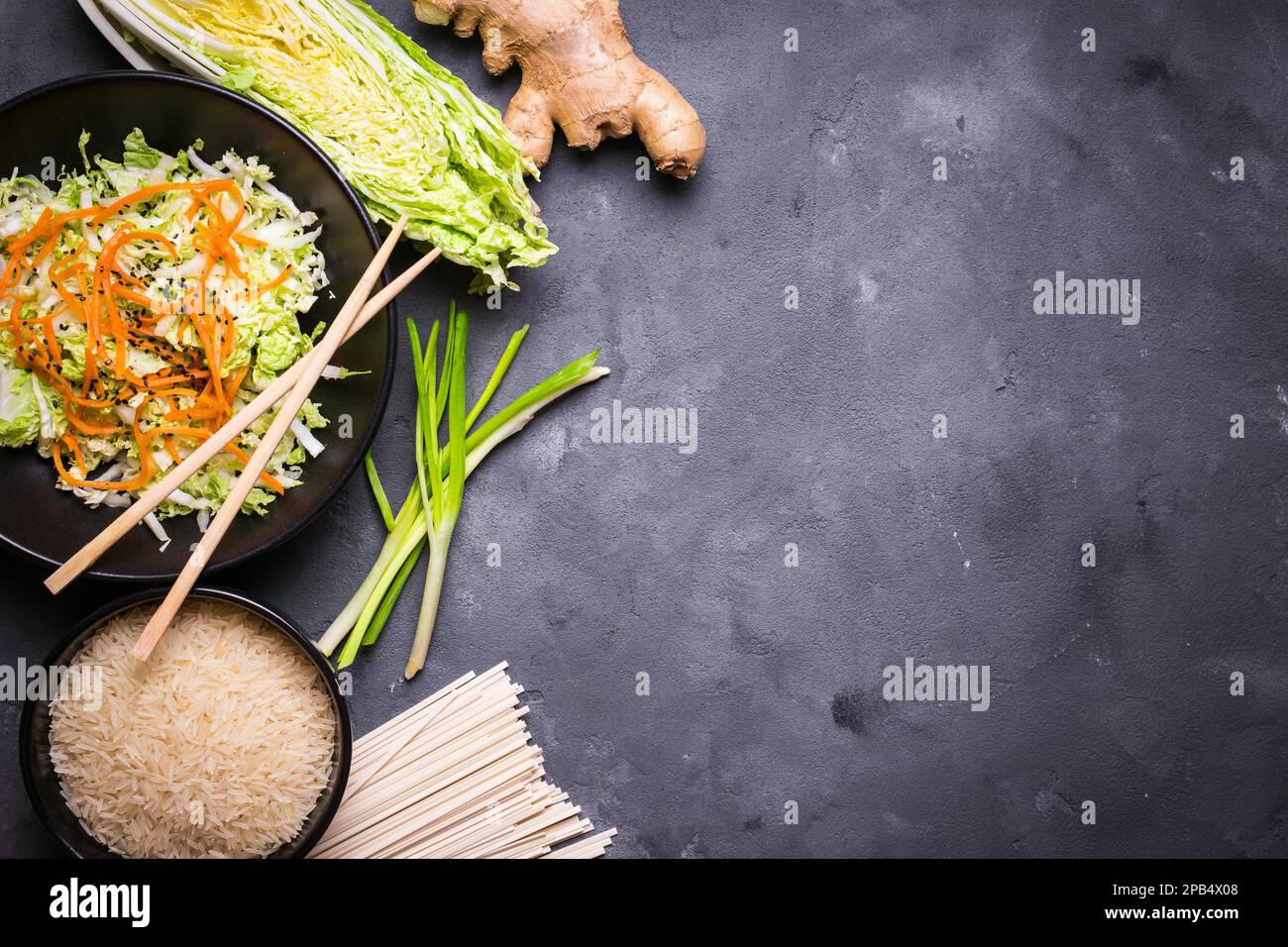 Zutaten für die Zubereitung des chinesischen Abendessens: Weizennudeln, Reis, napakohl, Ingwer, grüne Zwiebeln. Asiatische Kochzutaten. Draufsicht. Vorbereitung gesund Stockfoto