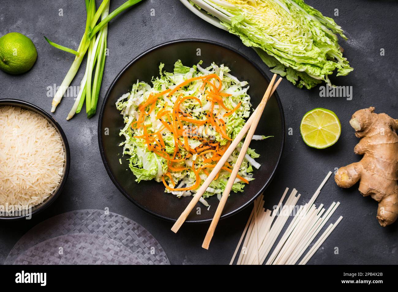 Vietnamesischer Salat. Frische Zutaten für die Zubereitung des vietnamesischen Abendessens: Reispapier, Reis, Nudeln, grüne Zwiebel, napakohl, Salat. Asiatische Kochzutat Stockfoto