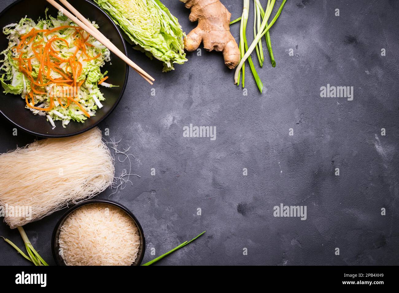 Zutaten für die Zubereitung des chinesischen Abendessens: Reisnudeln, Reis, napakohl, Ingwer, grüne Zwiebeln. Asiatische Kochzutaten. Draufsicht. Vorbereitung gesunde A Stockfoto