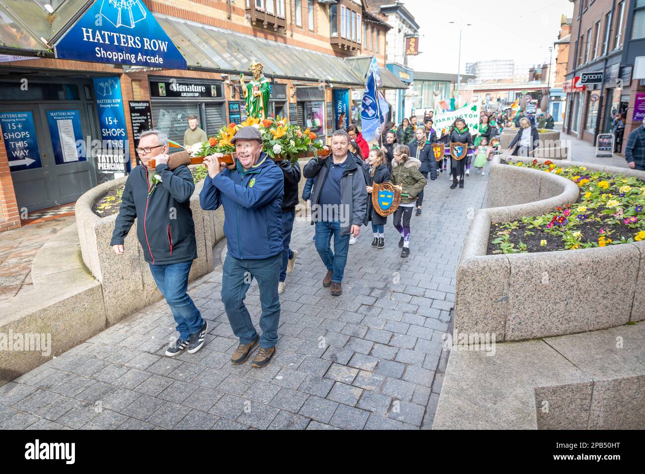 Warrington, Cheshire, Großbritannien - 12. März 2023 – Warrington Irish Club ist Gastgeber des St. Patrick's Day Parade. Beginn um 10,30 Uhr morgens vom Irish Club in der Orford Lane zum „River of Life“ in der Bridge Street im Stadtzentrum, wo ein kurzer Gottesdienst zum Gedenken an den Jahrestag des Bombenanschlags in Warrington abgehalten wurde. Die Statuen tragende Prozession führt durch das Stadtzentrum. Kredit: John Hopkins/Alamy Live News Stockfoto