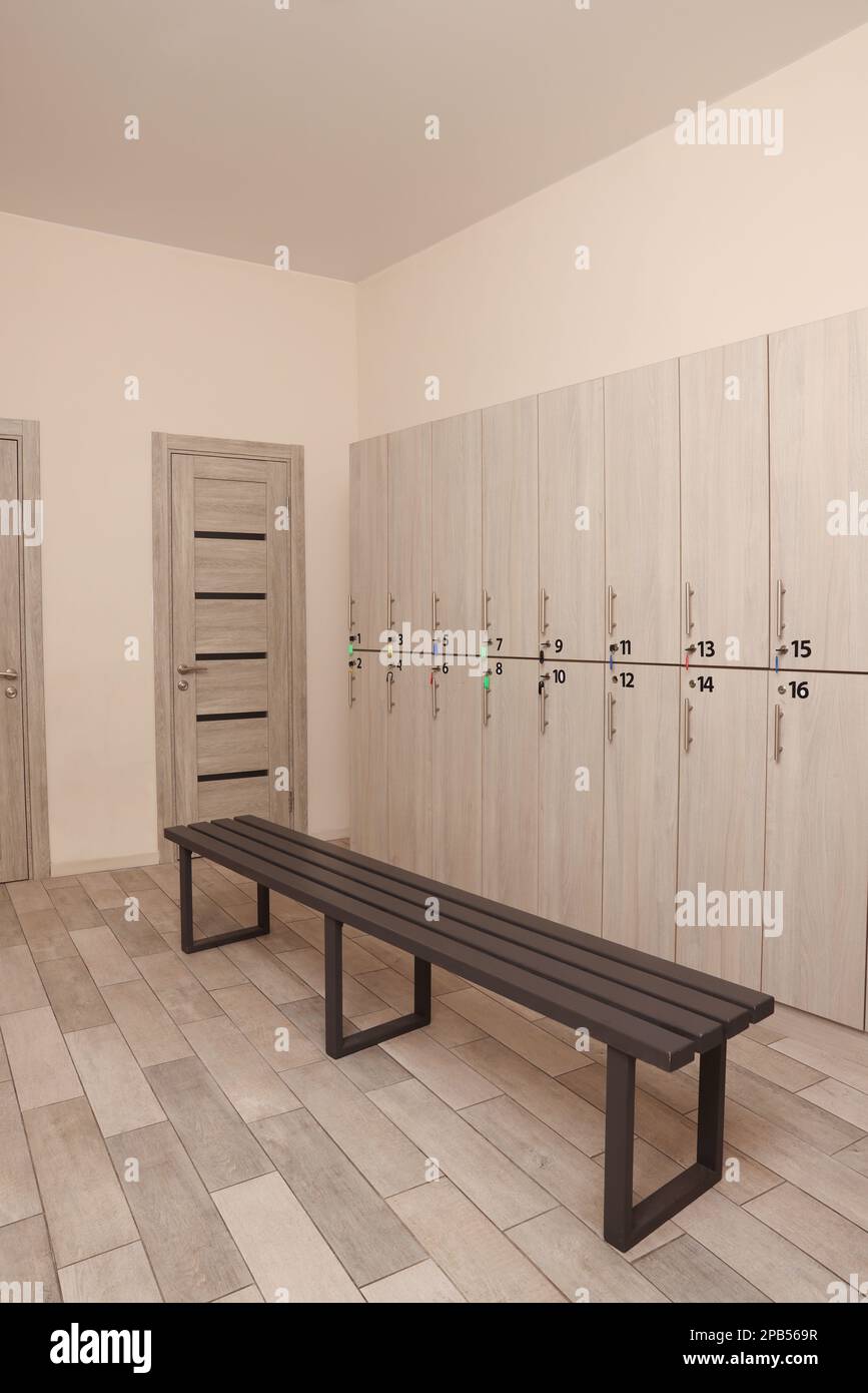 Holzbank und Schließfächer im Umkleideraum Stockfoto
