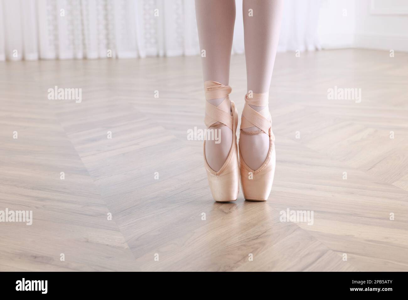 Kleine Ballerina, die Tanzbewegungen im Studio übt, die Beine schließen. Platz für Text Stockfoto