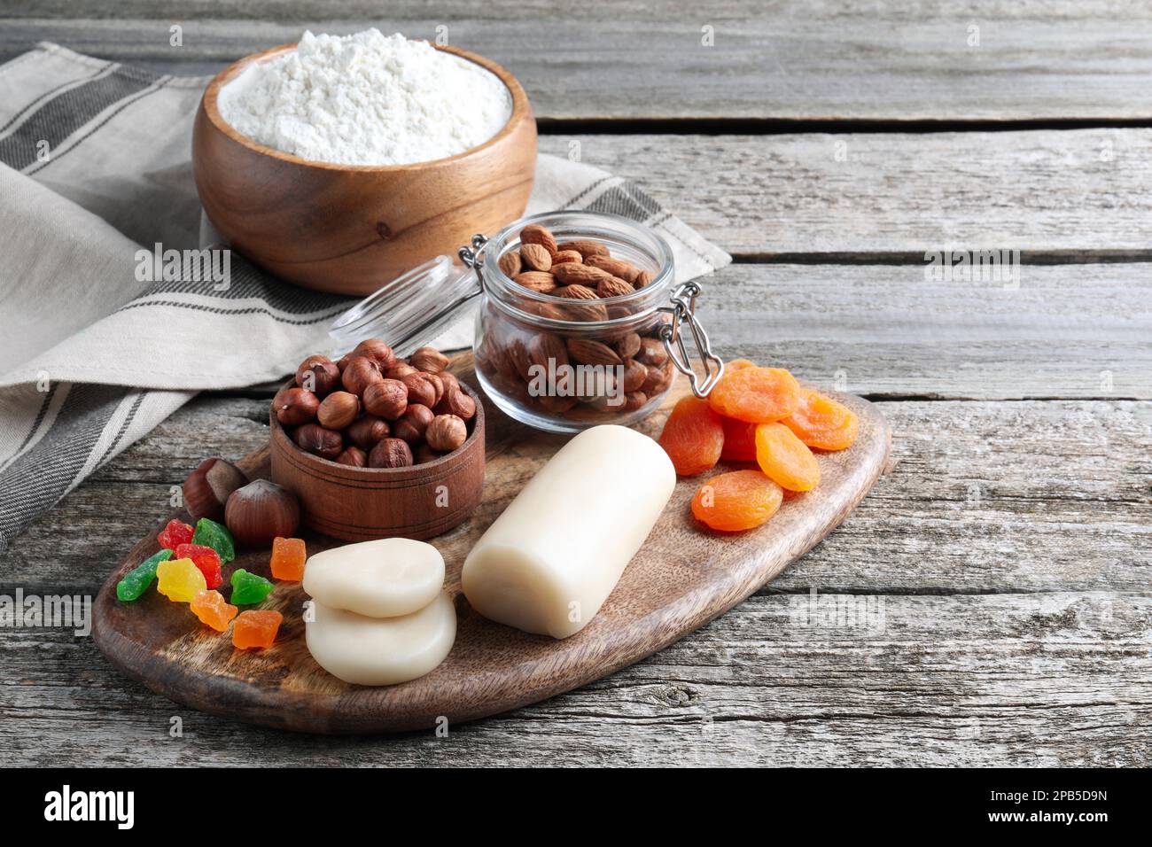 Marzipan und andere Zutaten für hausgemachtes Stollen auf einem Holztisch. Traditionelles deutsches Weihnachtsbrot backen Stockfoto