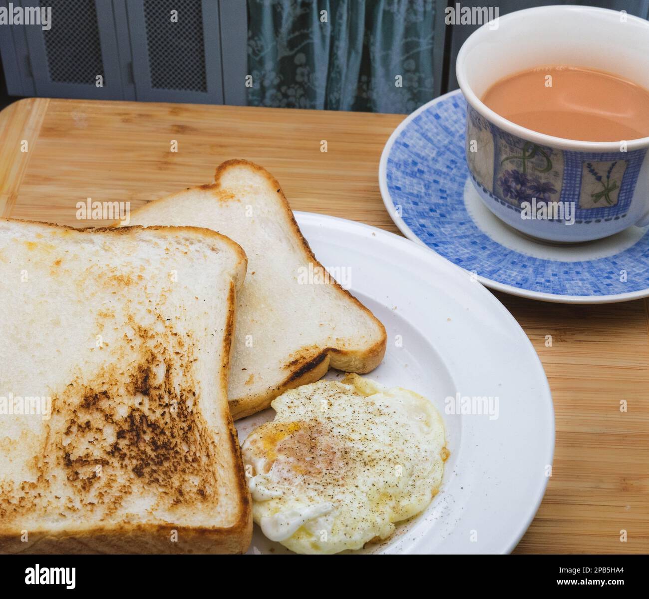 Englisches Frühstück - Tee mit Ei und Toast, Honig/Marmelade Stockfoto