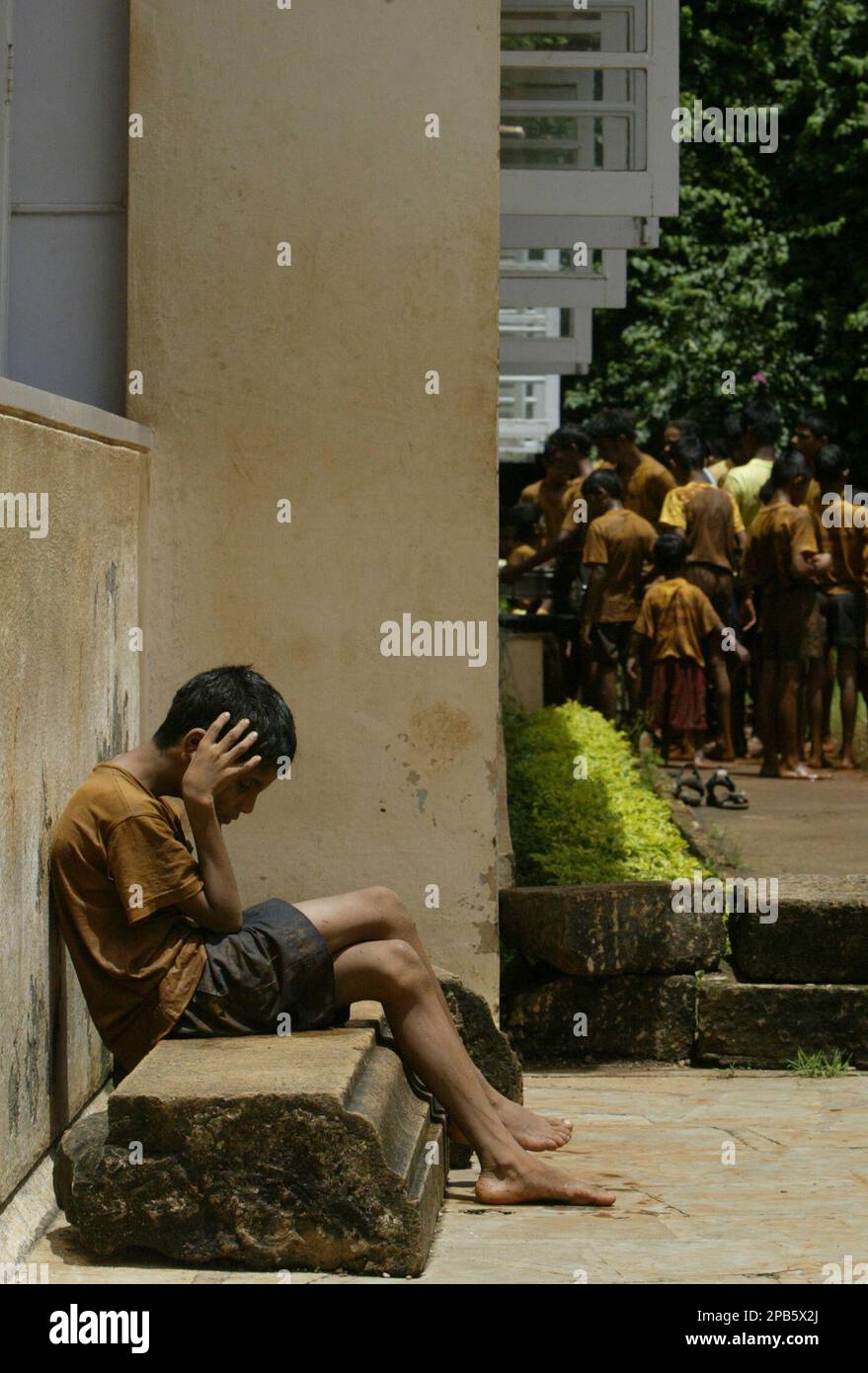Inmates Pyramid A visually impaired child sits after playing with mud and water on the ...