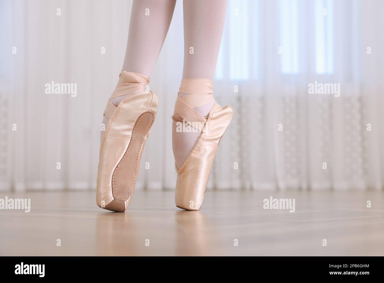 Kleine Ballerina, die Tanzbewegungen im Studio übt, die Beine schließen. Platz für Text Stockfoto