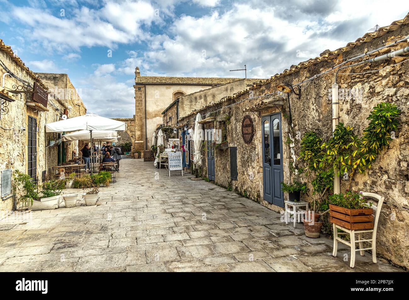 Werfen Sie einen Blick auf das sizilianische Küstendorf Marzamemi mit den Häusern, die heute zu Restaurants und Souvenirläden geworden sind. Marzamemi, Sizilien Stockfoto