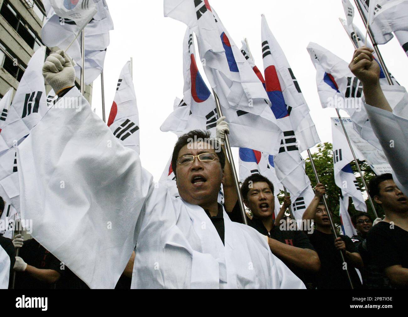 Former South Korean intelligence agents shout slogans as they hold national flags at a rally to commemorate the 62nd anniversary of the peninsula's Liberation Day from Japan's 1910-45 colonial rule near the Japanese Embassy in Seoul, South Korea, Wednesday, Aug. 15, 2007. (AP Photo/Lee Jin-man) Stockfoto