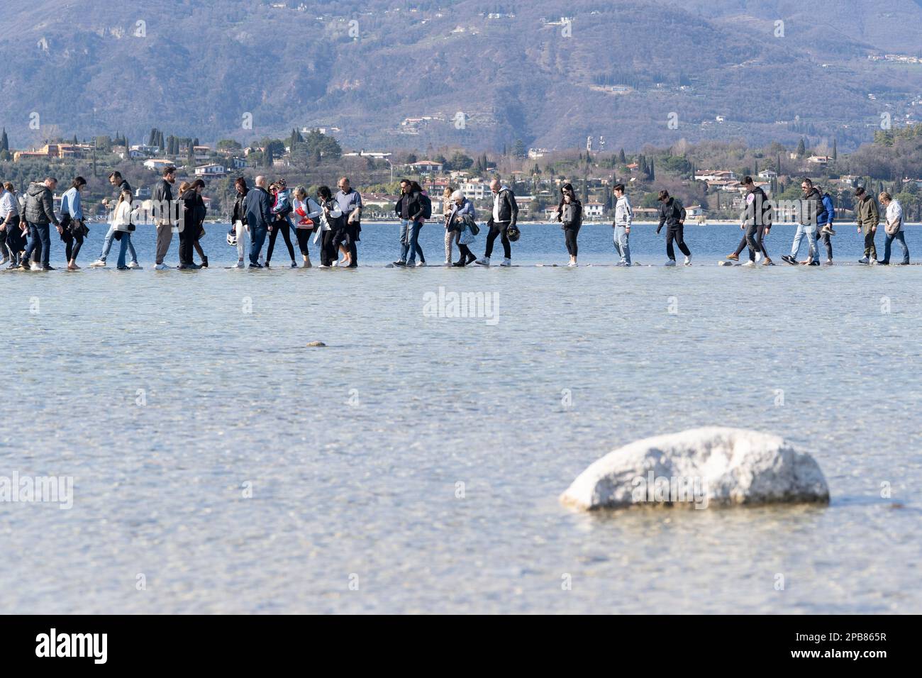 12. März 2023: Manerba del Garda, Brescia, Italien 12. März, Dürre in norditalien Menschen gehen von Punta Belvedere nach Isola dei Conigli in einem Teil des Gardasees, der aufgrund der schweren Dürre ungewöhnlich trocken ist (Bild: © Matteo Biatta/ZUMA Press Wire) REDAKTIONELLE VERWENDUNG! Nicht für den kommerziellen GEBRAUCH! Stockfoto