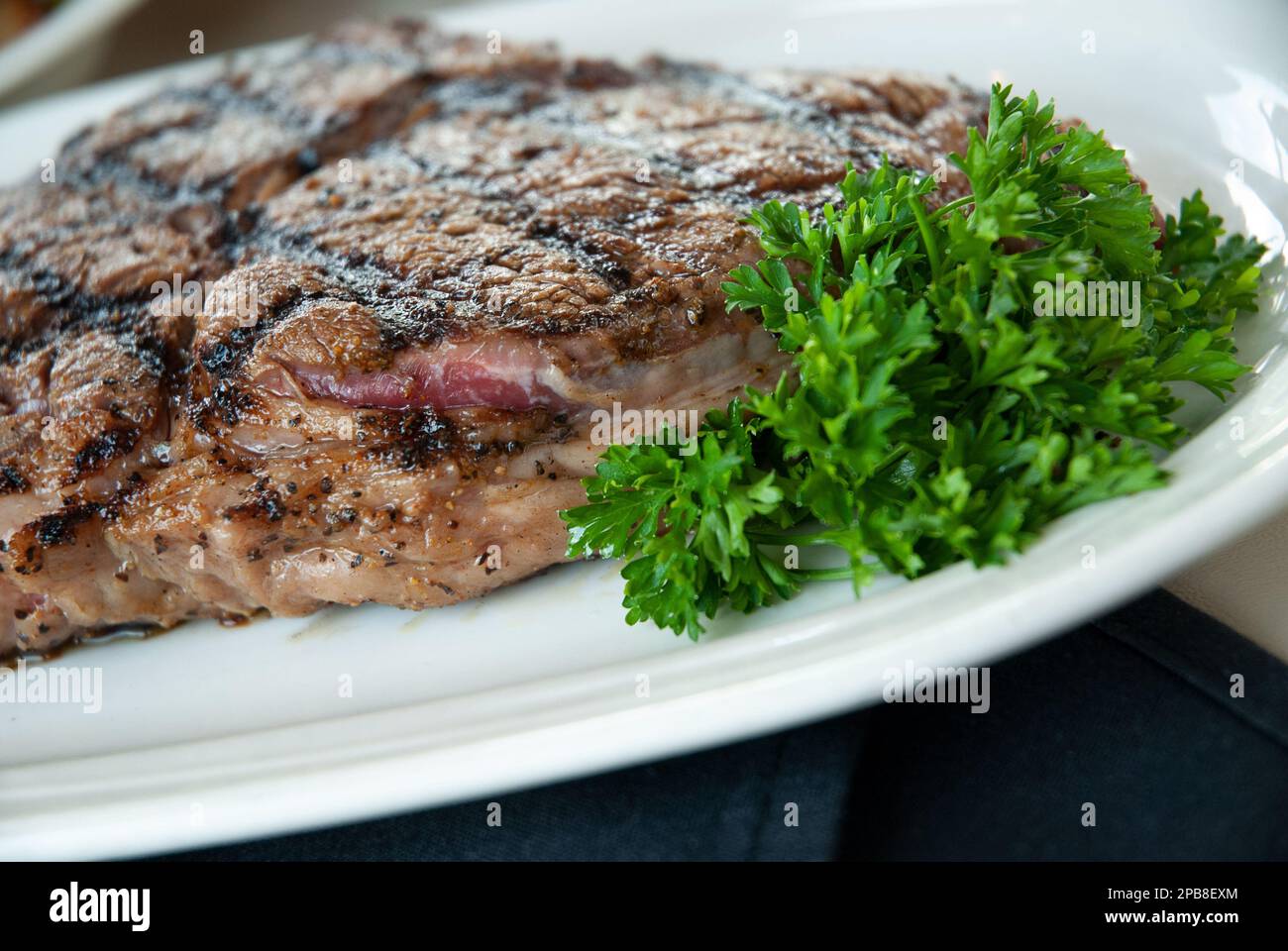 Nahaufnahme eines Steaks, garniert mit Petersilie Stockfoto