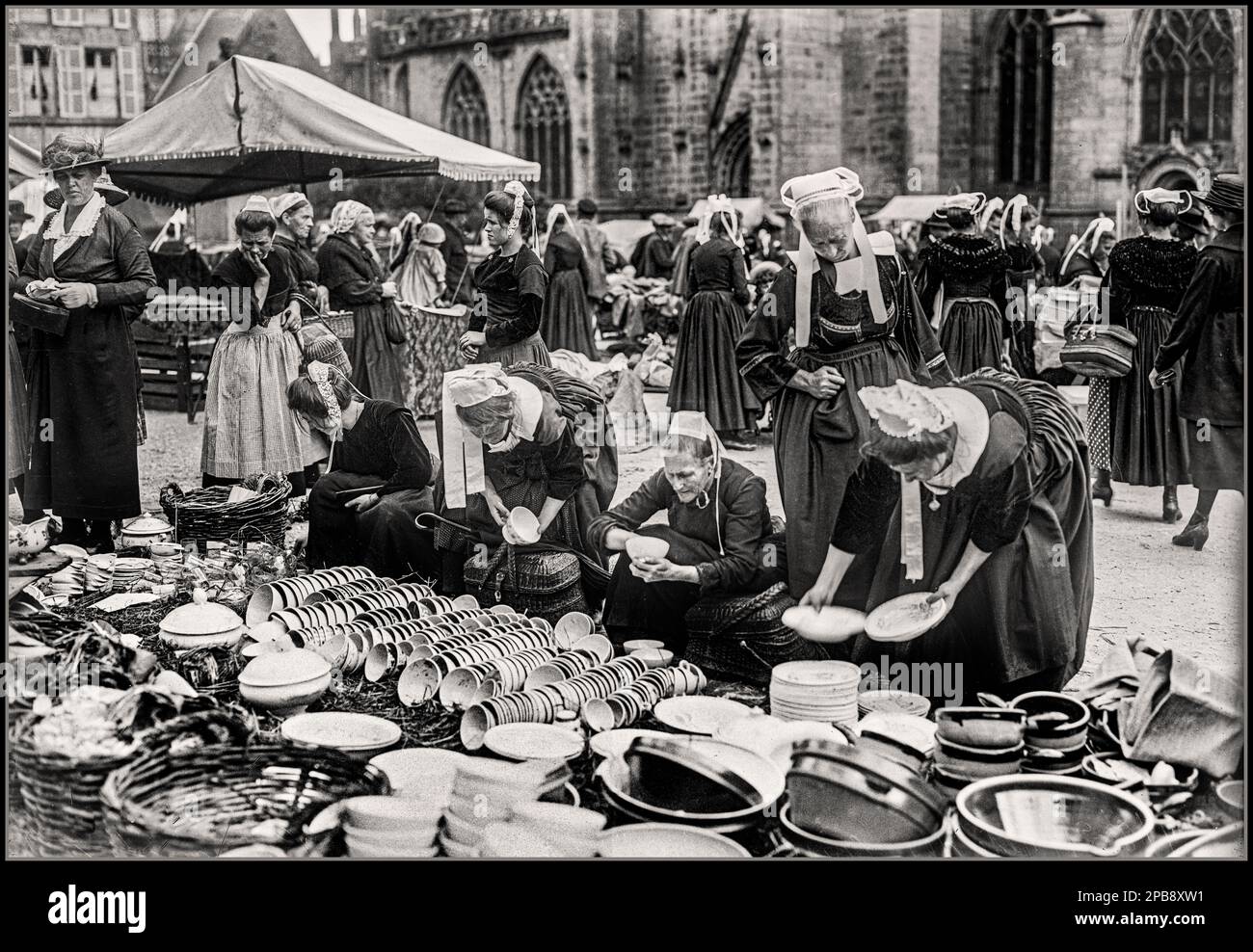 Alte 1920er-jährige BRETAGNE-Damen in historischem französischem Bretonkostüm auf dem Markt in Quimper Brittany Bigoudènes auf dem Platz der Saint-Corentin-Kathedrale in Quimper (Finistère, Frankreich) Stockfoto