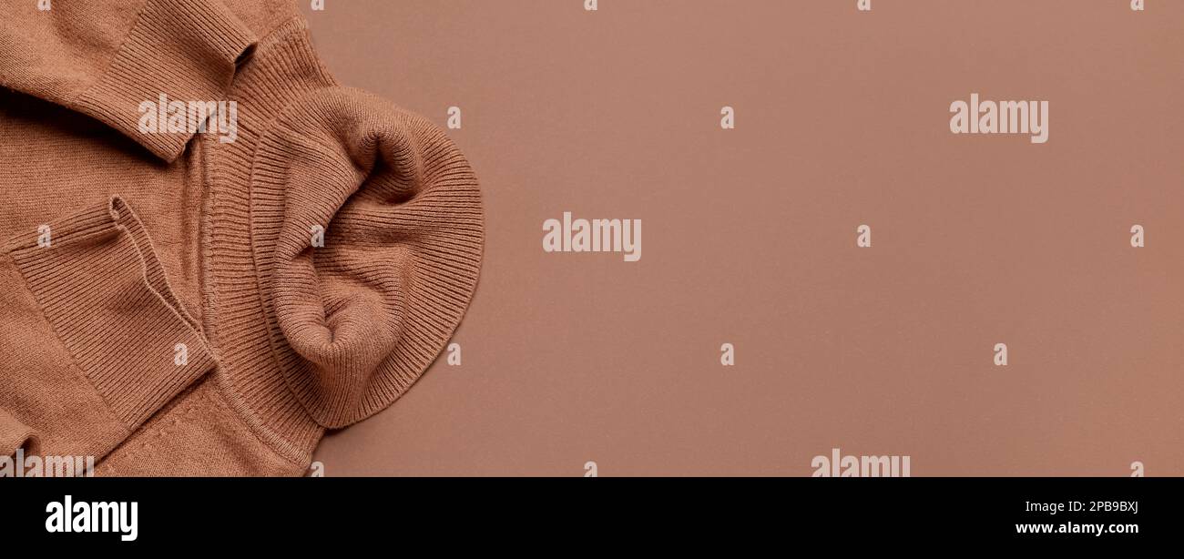 Stylischer Pullover auf braunem Hintergrund mit Platz für Text Stockfoto