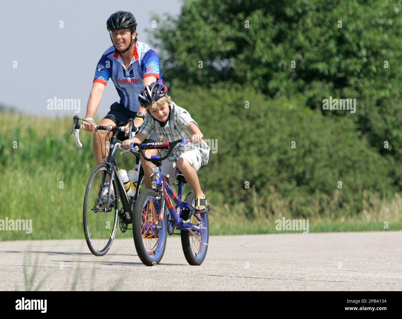 Democratic presidential hopeful, former North Carolina Sen. John Edwards, left, rides with his son Jack during the Des Moines Register's Annual Great Bike Ride Across Iowa, Wednesday, July 25, 2007, near Dumont, Iowa. (AP Photo/Charlie Neibergall) Stockfoto