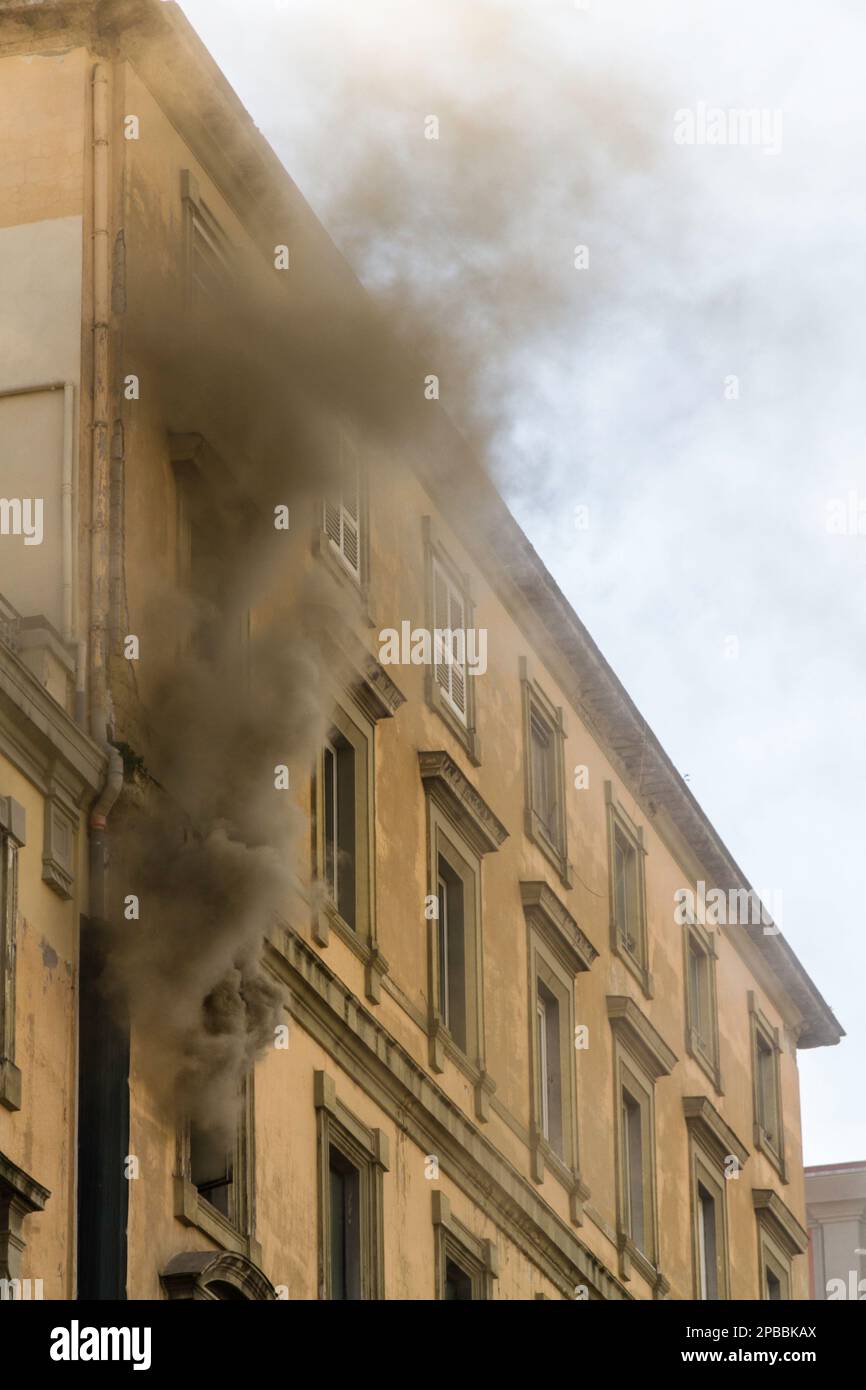 Ein einheimischer Wohnungsbrand mit Rauch, der aus dem Fenster strömt. Garibaldi Square, Neapel, Italien, Porträt Stockfoto