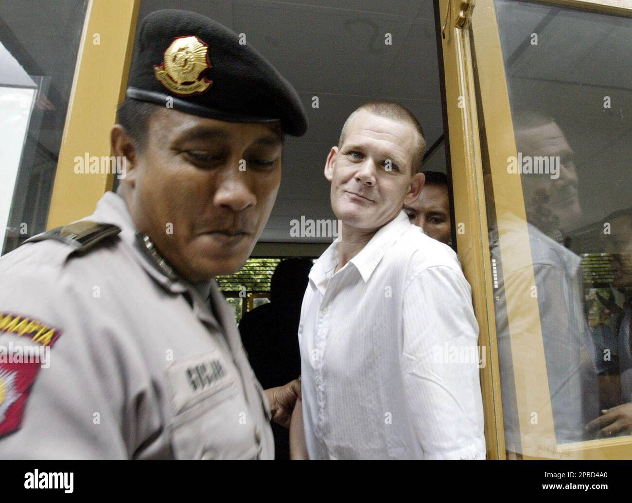 Celebrity chef Gordon Ramsay's brother Ronald, right, is escorted by Indonesian police officer after his hearing trial at Denpasar district court, Bali, Indonesia, Thursday, June 21, 2007. Ramsay was arrested last February for possession of 0.1 gram heroin on resort island of Bali. (AP Photo/Firdia Lisnawati) Stockfoto
