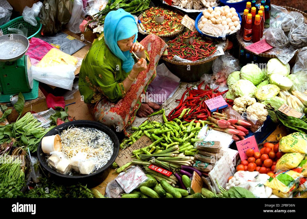 A Muslim trader lights up a cigarette inside a market, which is mostly ...