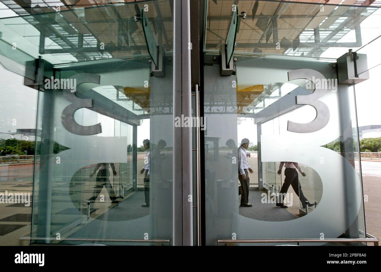 A man walks out of the entrance of the newly-completed section of Singapore's Changi International Airport Terminal 3, which features unique roof architecture allowing natural light into the building while keeping the tropical heat out, Tuesday May 29, 2007. The new terminal which officially opens in 2008 will add a capacity of 22 million passengers a year bringing the total capability of the city-state's airport to 70 million. (AP Photo/Wong Maye-E) Stockfoto