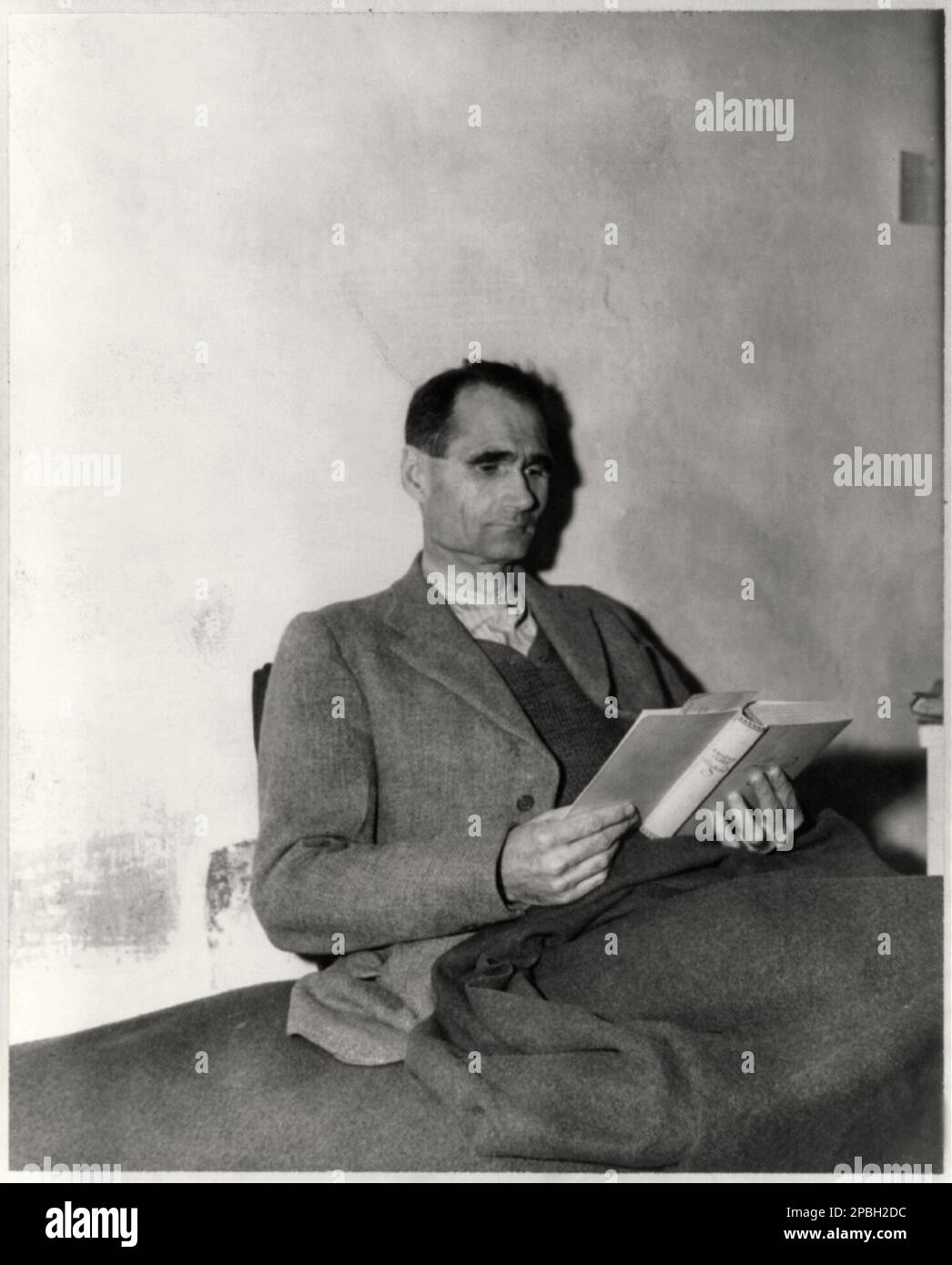 1945 , DEUTSCHLAND : die deutsche SS RUDOLF HESS ( 1894 - 1987 ) liest das Buch Jugend von Ernst Claes im Landsberg-Gefängnis vor . Foto: Special Corps US Army . War eine prominente Persönlichkeit in Nazideutschland und fungierte als Adolf Hitlers Stellvertreter in der Nazipartei. Am Vorabend des Krieges mit der Sowjetunion flog er allein nach Schottland, um Frieden mit dem Vereinigten Königreich auszuhandeln, wurde aber stattdessen verhaftet. Er wurde in Nürnberg angeklagt und im Gefängnis Spandau zu lebenslanger Haft verurteilt, wo er bis zu seinem Tod im Jahr 1987 blieb, als er durch ein Kabel stranguliert wurde. Die offizielle Todesursache war Stockfoto