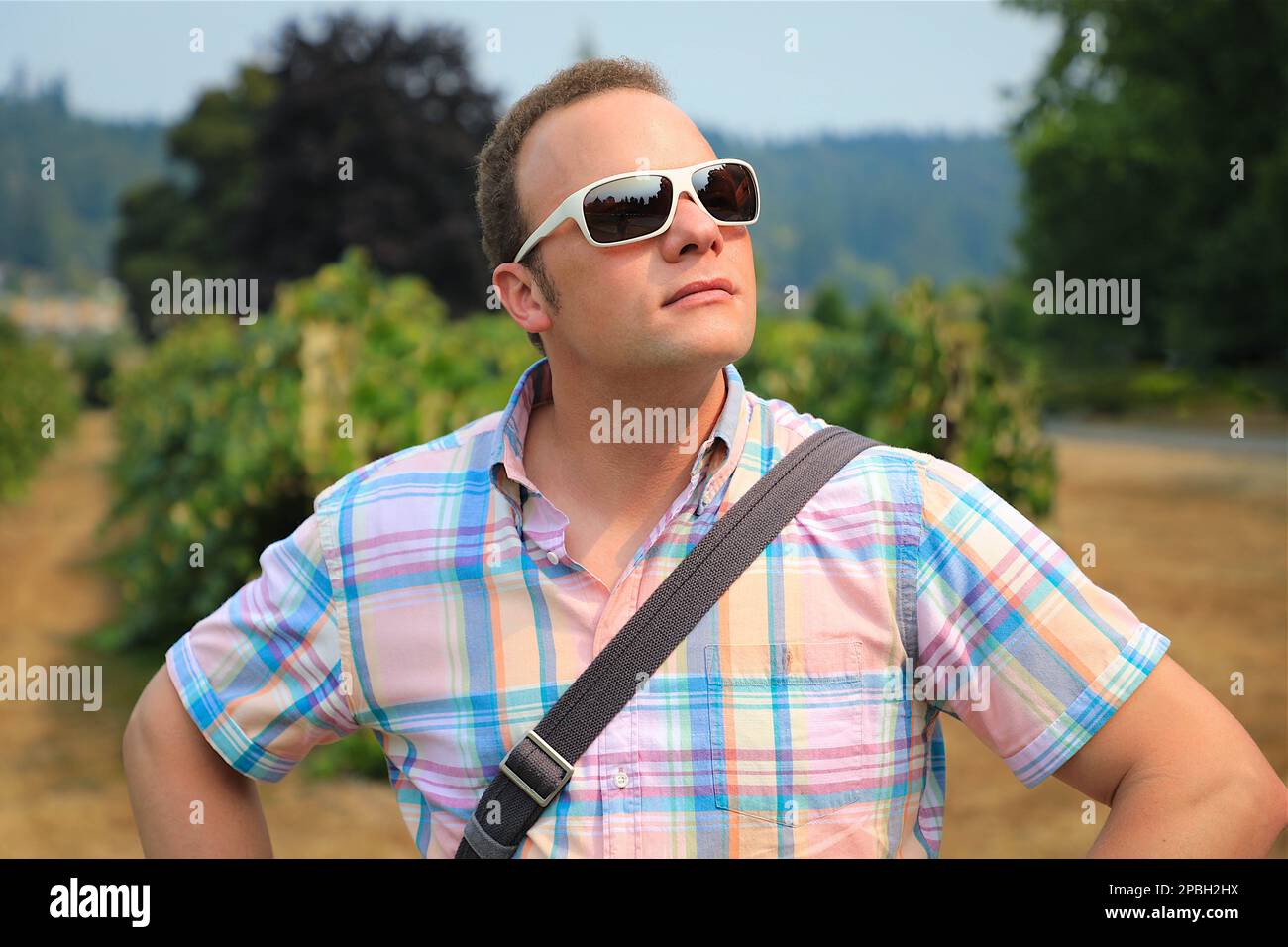 Schöner Mann in Sonnenbrille, der Nachmittagssonnenlicht in einem Garten in Washington genießt Stockfoto