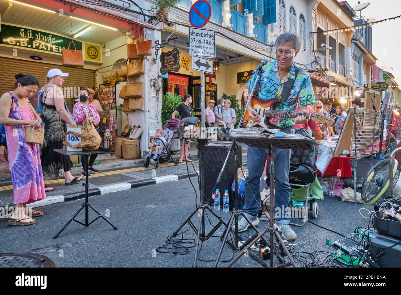Ein Musiker, der klassische Rocksongs auf seiner E-Gitarre spielt, unterhält Besucher auf dem Sunday Walking Street Market in Phuket, Phuket Town, Thailand Stockfoto