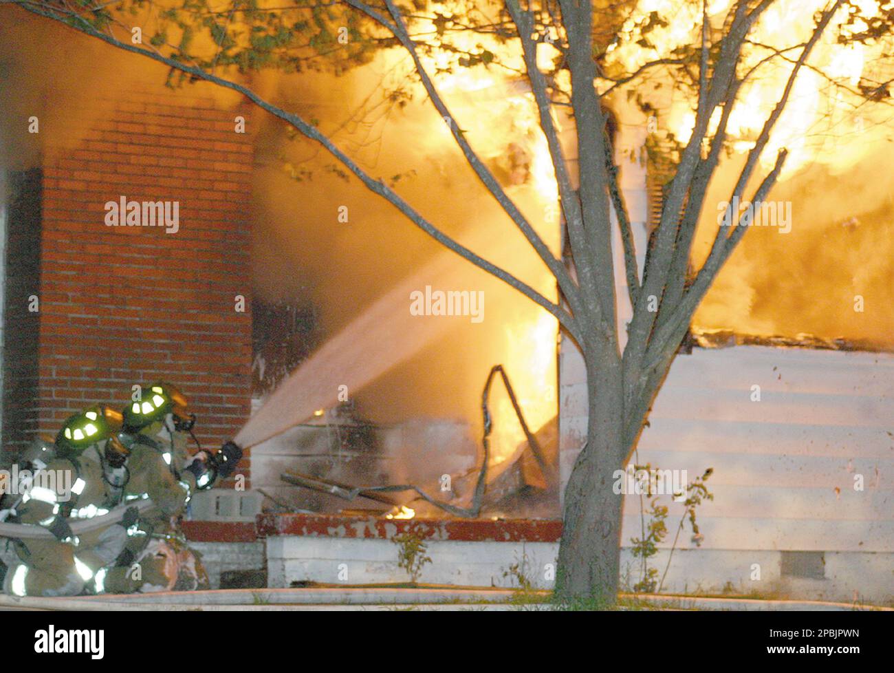 Firefighters spray the entrance to a burning building in Searcy, Ark