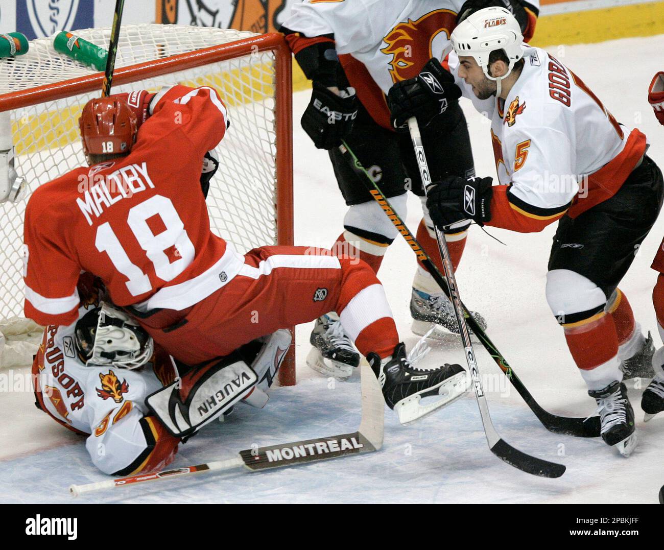 Detroit Red Wings' Kirk Maltby (18) lands on Calgary Flames goalie ...