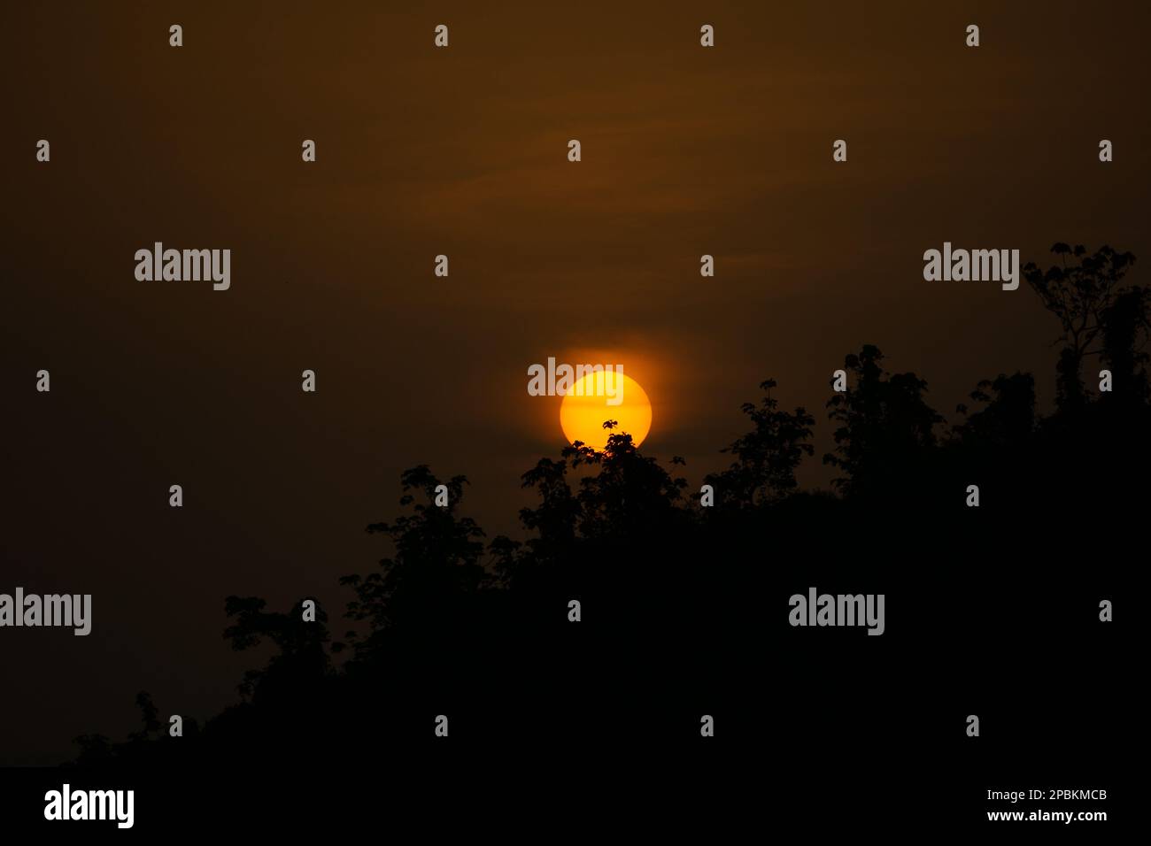 Wunderschöne Aussicht auf den Sonnenaufgang. Wolken auf der einen Seite und die aufgehende Sonne über den Bergen auf der anderen. Hügelige Region Bangladesch. Foto von Meghbari, Stockfoto