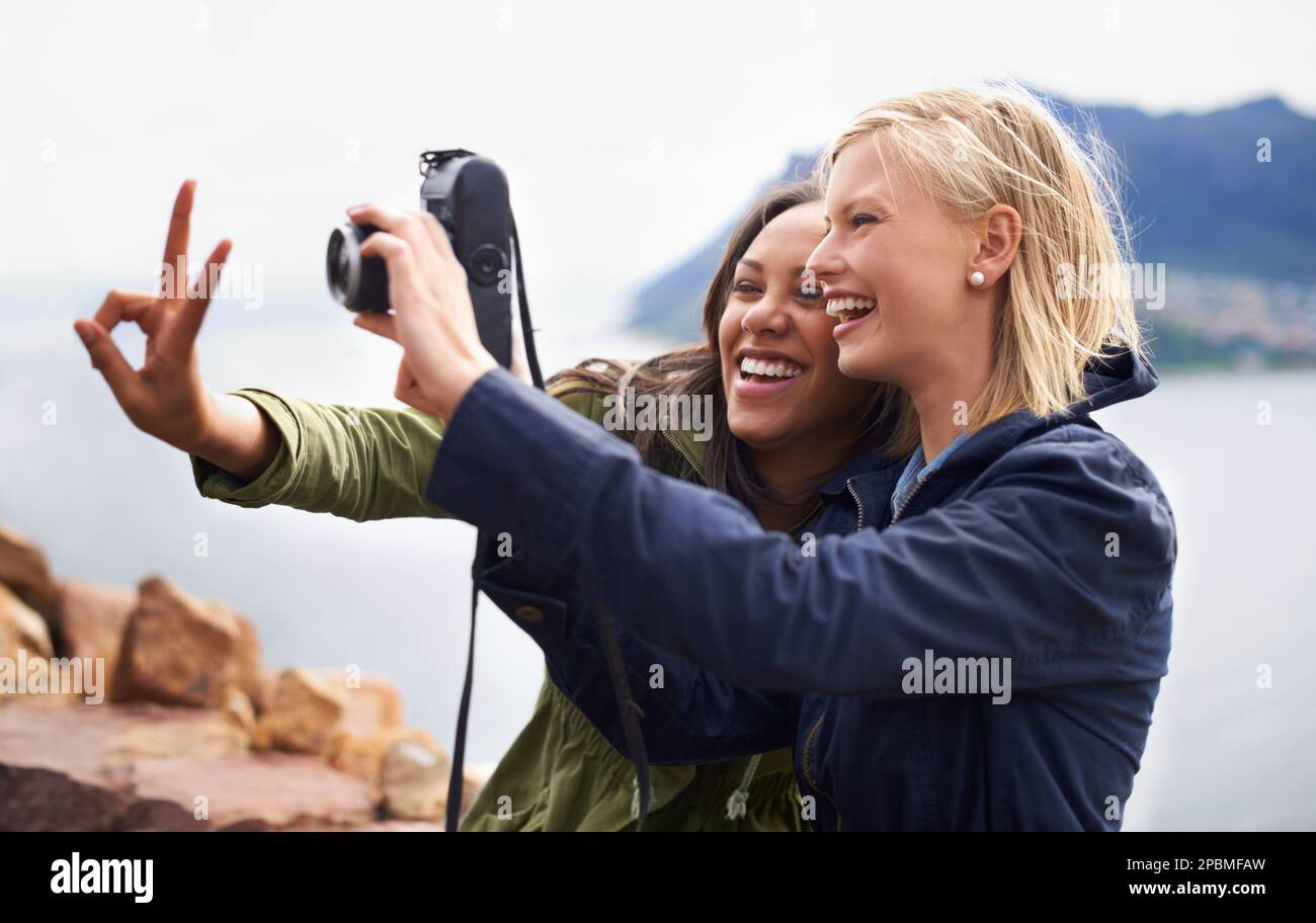 Momentaufnahmen des Friedens. Ein Foto von zwei jungen Frauen, die ein Selbstporträt auf einem Roadtrip machen. Stockfoto