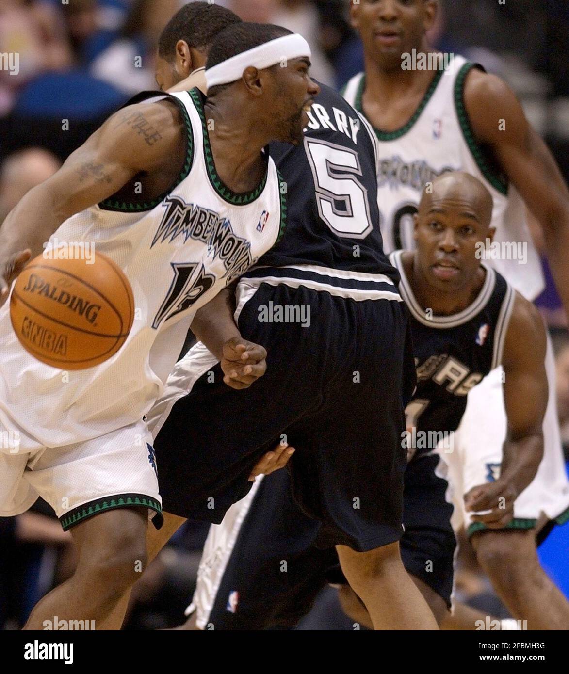 Minnesota Timberwolves' Mike James, left, drives past San Antonio Spurs' Robert Horry (5) and gets picked up by the Spurs' Jacque Vaugh, right, during the second quarter of an NBA basketball game Friday, April 13, 2007, in Minneapolis. James had a game-high 23 points, but San Antonio won 110-91. (AP Photo/Tom Olmscheid) Stockfoto