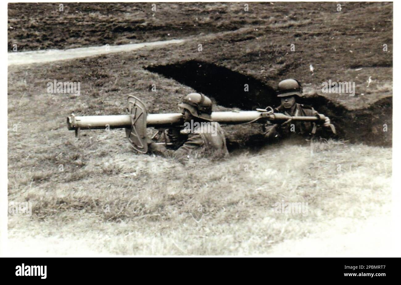 2. Weltkrieg Schwarzweiß Foto Deutsche Soldaten bereiten sich darauf vor, einen deutschen Panzer-Raketenwerfer Panzerschreck aus einem Graben auf einem militärischen Trainingsgelände in Deutschland abzufeuern 1944 Stockfoto