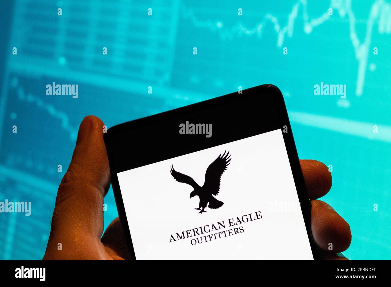 China. 15. Februar 2023. In dieser Fotoabbildung wird das American Eagle-Logo des amerikanischen Bekleidungs- und Accessoires-Händlers auf einem Smartphone mit einer Grafik des Börsenindex im Hintergrund angezeigt. (Kreditbild: © Budrul Chukrut/SOPA Images via ZUMA Press Wire) NUR REDAKTIONELLE VERWENDUNG! Nicht für den kommerziellen GEBRAUCH! Stockfoto