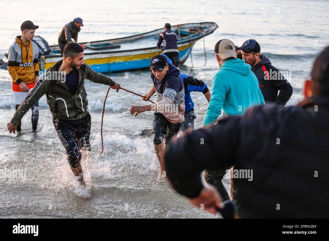 Gaza, Palästina. 12. März 2023. Palästinensische Fischer ziehen Mantarochen (Manta birostris), nachdem sie am Strand entlang der Küste in Gaza-Stadt angespült wurden. Palästinensische Fischer verlassen das Mittelmeer auf ihren Fischerbooten mit einem Haufen Mantarochen, die angespült werden, während Dutzende von Palästinensern an der Küste von Gaza-Stadt darauf warten, sie zu beobachten. Kredit: SOPA Images Limited/Alamy Live News Stockfoto