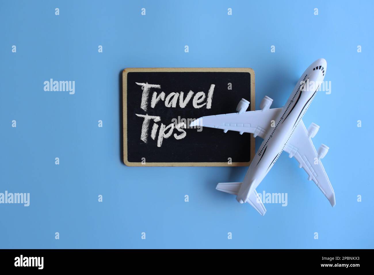 Spielzeugflugzeug und Tafel mit REISETIPPS für Text. Reise- und Transportkonzept Stockfoto