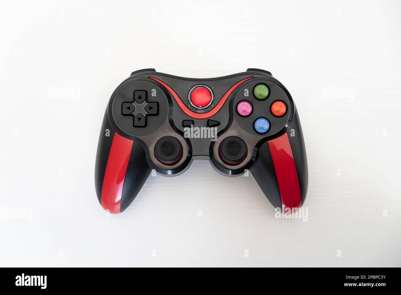 Moderner schwarz-roter Gamepad-Joystick auf weißem Hintergrund. Draufsicht Stockfoto