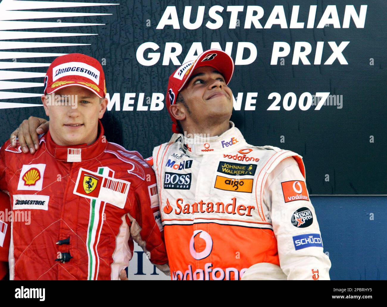 British McLaren driver Lewis Hamilton, right, poses with Finnish Ferrari driver Kimi Raikkonen on the podium after the Australian Grand Prix in Melbourne, Sunday, March 18, 2007. Raikkonen won the race and Hamilton was third. (AP Photo/Oliver Multhaup) Stockfoto