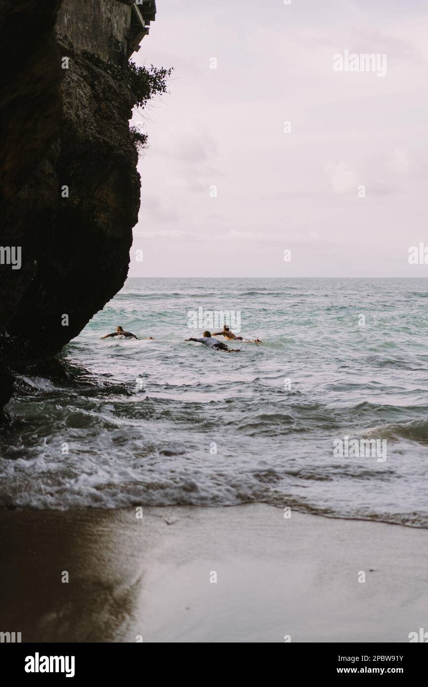 Ein Mann mit einem Surfbrett geht zum Uluwatu Surfplatz. Stockfoto