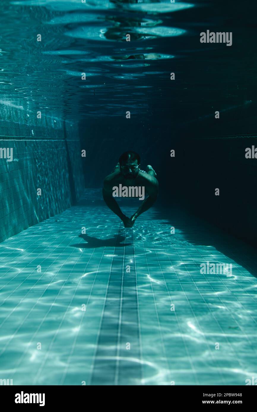 Mann schwimmt im Pool unter Wasser. Stockfoto