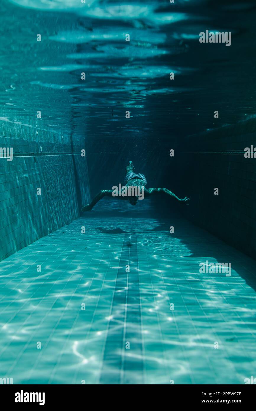 Mann schwimmt im Pool unter Wasser. Stockfoto