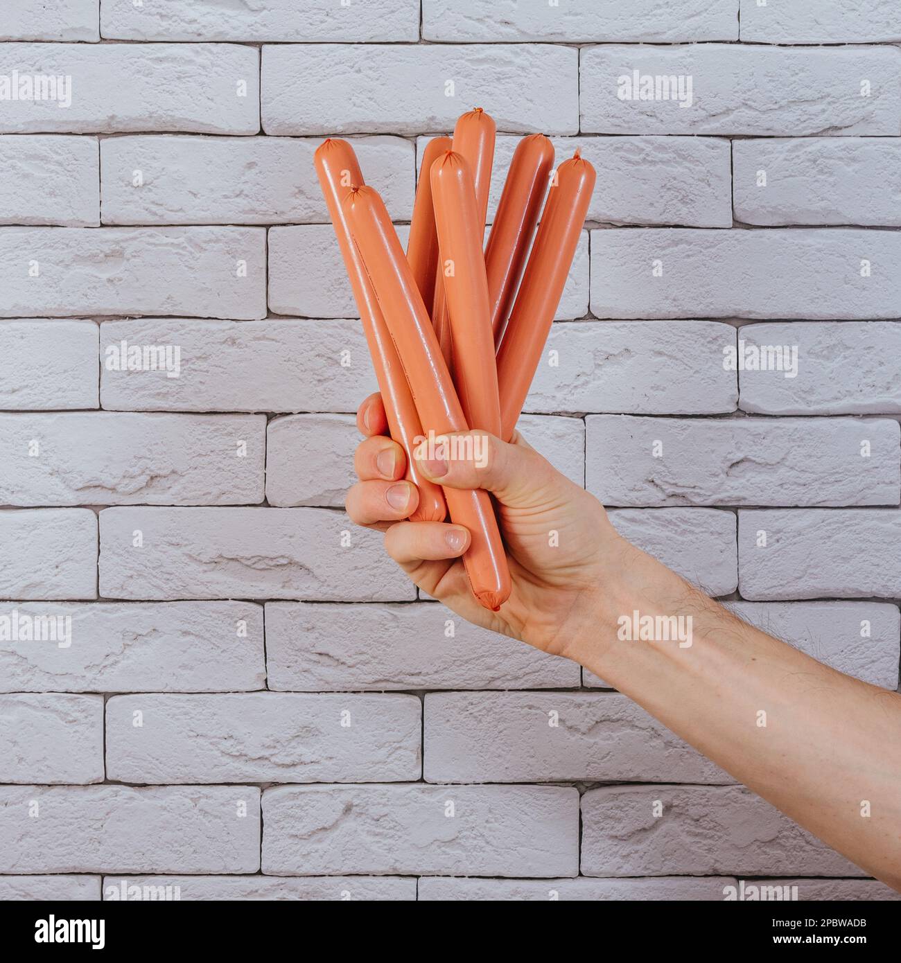 Hand haltende Hot-Dog-Würstchen Stockfoto