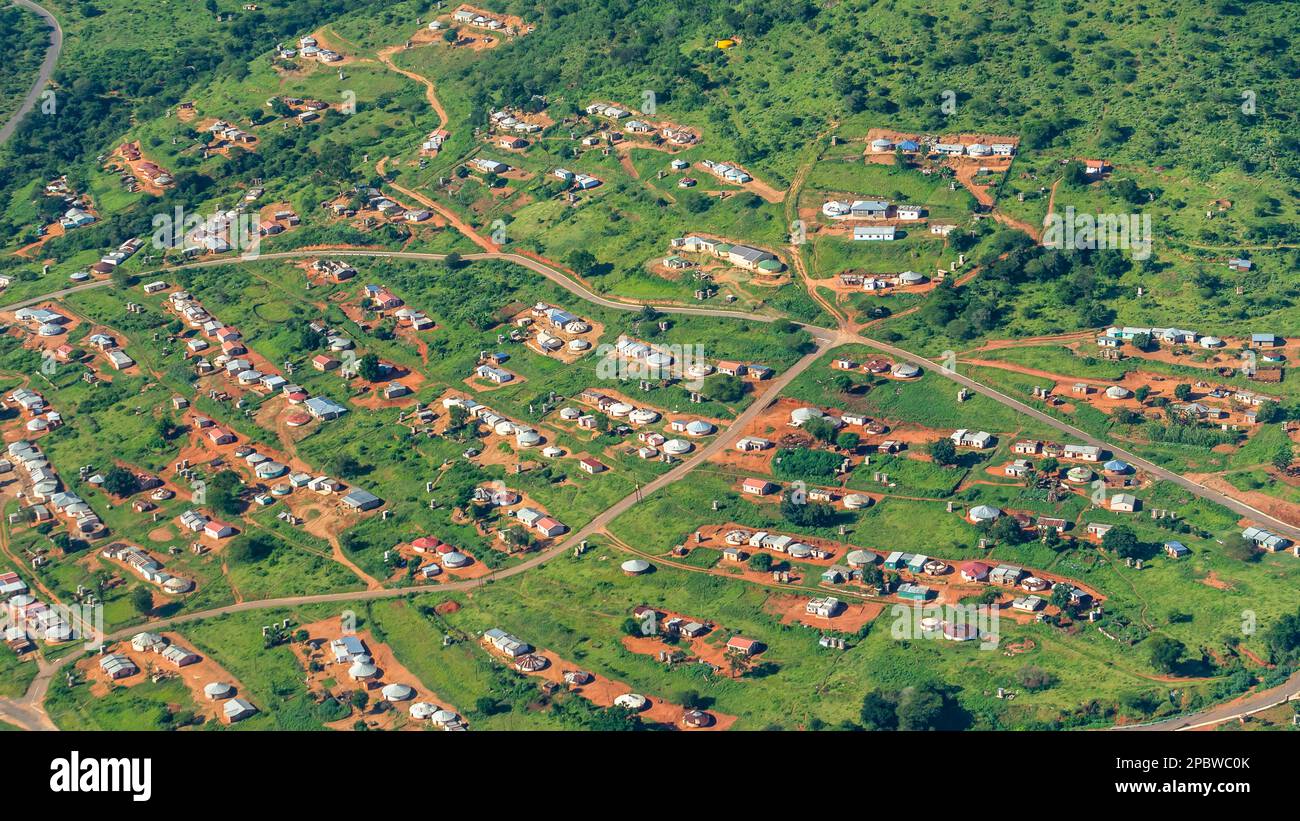 Über dem Kopf fliegendes Foto von Stammesfamilienhäusern der Zulu-Familie Landschaftsgestaltung in grüner, üppiger Sommervegetation des Inanda-Tals. Stockfoto