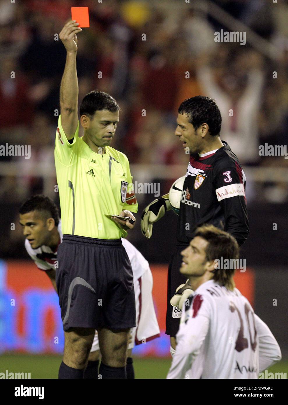 Referee Bernardino Vazquez shows Sevilla's Aitor Ocio, bottom, a red card after he tackled Barcelona's Ronaldinho in the box during their Spanish league soccer match Saturday, March 3 2007, in Seville, southern Spain. (AP Photo/Armando Franca) Stockfoto
