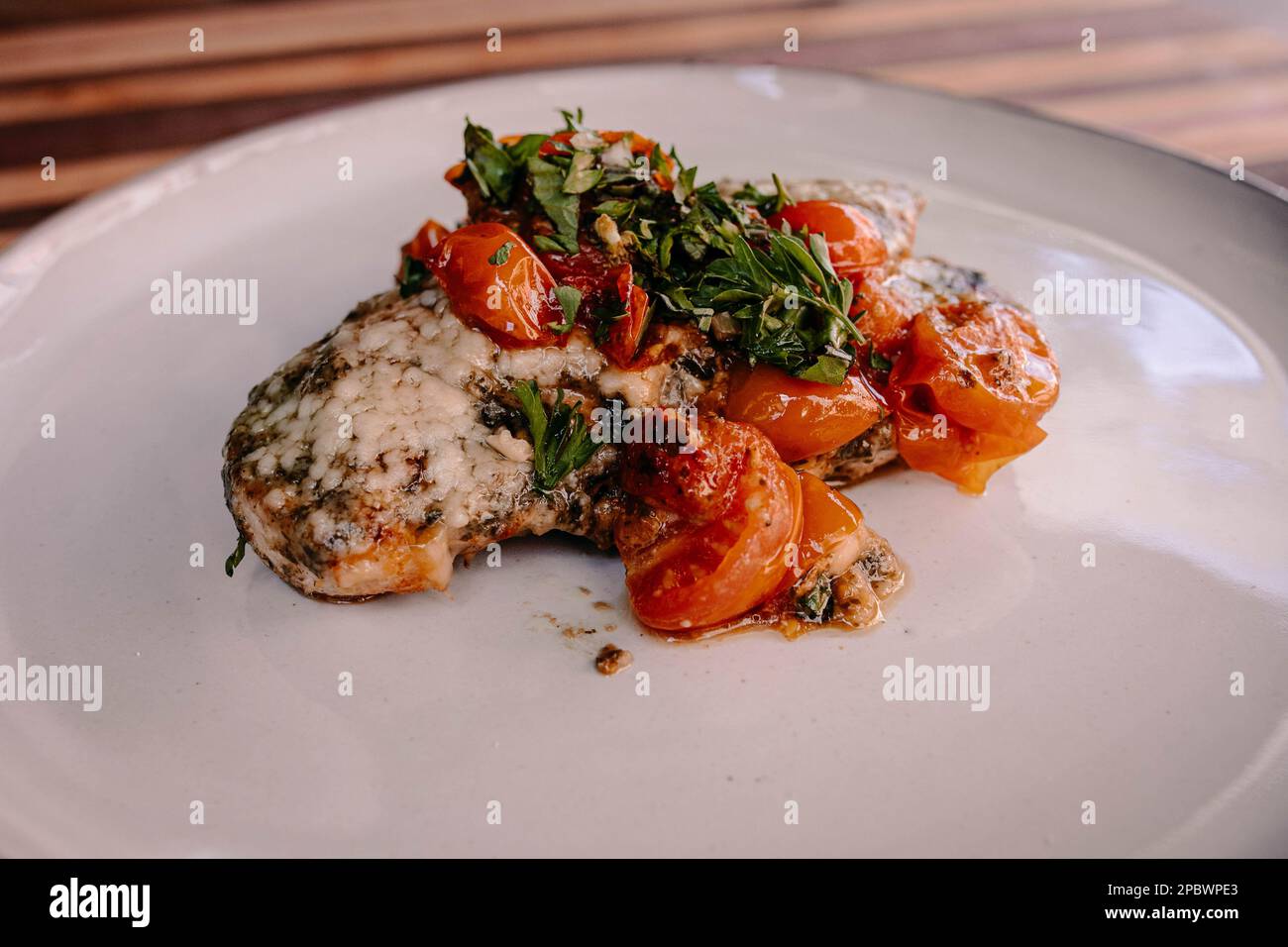 Keto- und Paleo-Hühnchen-Parmesan-Gericht auf Keramikplatte Stockfoto
