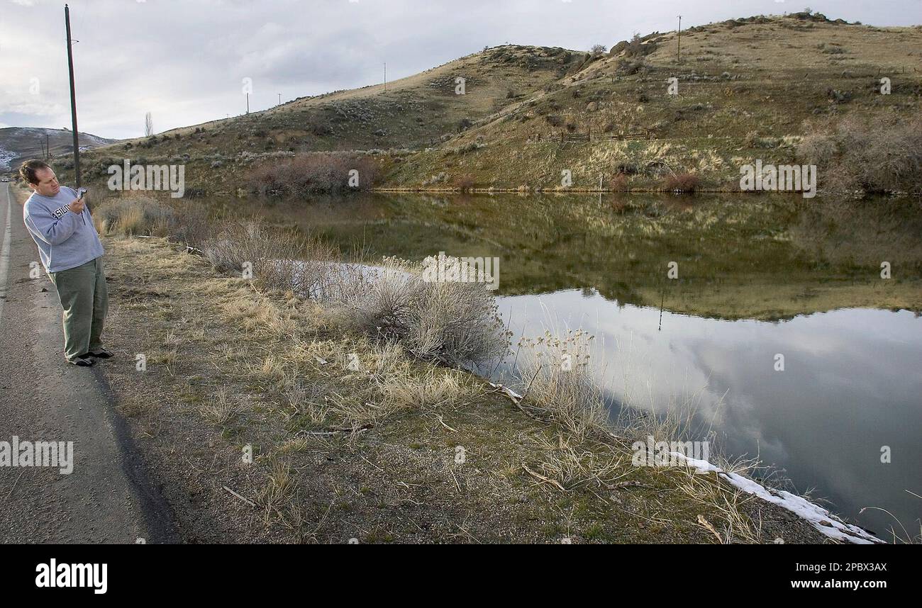 Kevan Kjar takes photographs at the edge of a pond near Emmett, Idaho