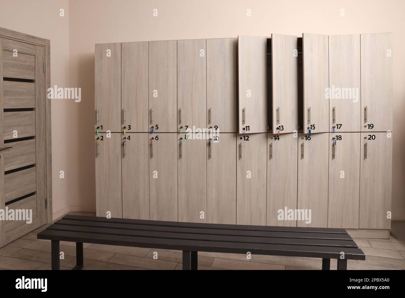 Holzbank und Schließfächer im Umkleideraum Stockfoto