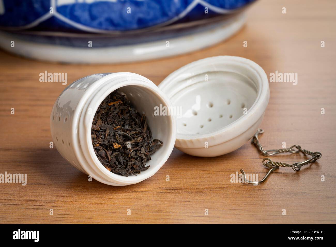 Offenes weißes Keramik-Teessieb mit getrockneten chinesischen Kee Mun-Teeblättern aus nächster Nähe, um mit der Teezubereitung zu beginnen Stockfoto