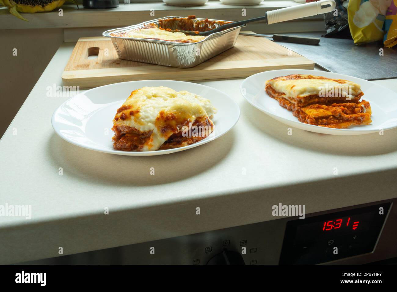 Stücke gebackener frischer Lasagne auf Tellern, Essen vom Markt Stockfoto