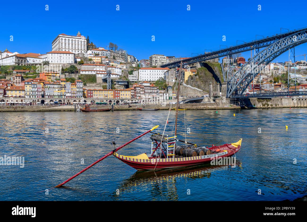 Der wunderschöne alte Hafen von Porto mit der Cais da Ribeira auf der gegenüberliegenden Seite des Flusses Douro. Die eindrucksvolle Bogenbrücke ist die Luis-I-Brücke. Stockfoto