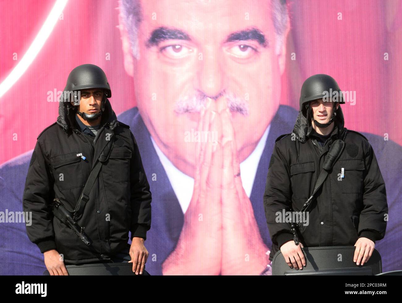 Lebanese police commandos stand guard near a poster showing former ...