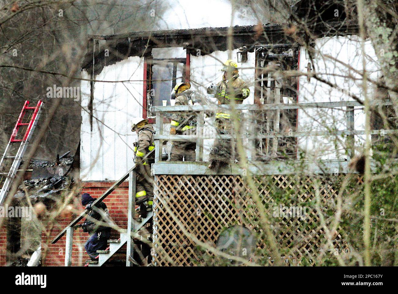 A detective with the Blount County Sheriff's Office and members of the Blount County Fire Department and the Friendsville Fire Department exit a home where four children died in a fire Tuesday, Feb. 6, 2007, in Friendsville, Tenn. A man and woman escaped from the burning home, carrying their 2-year-old child to safety, Sheriff James Berrong said. (AP Photo/The Daily Times, Daryl Sulllivan) ** MANDATORY CREDIT ** Stockfoto